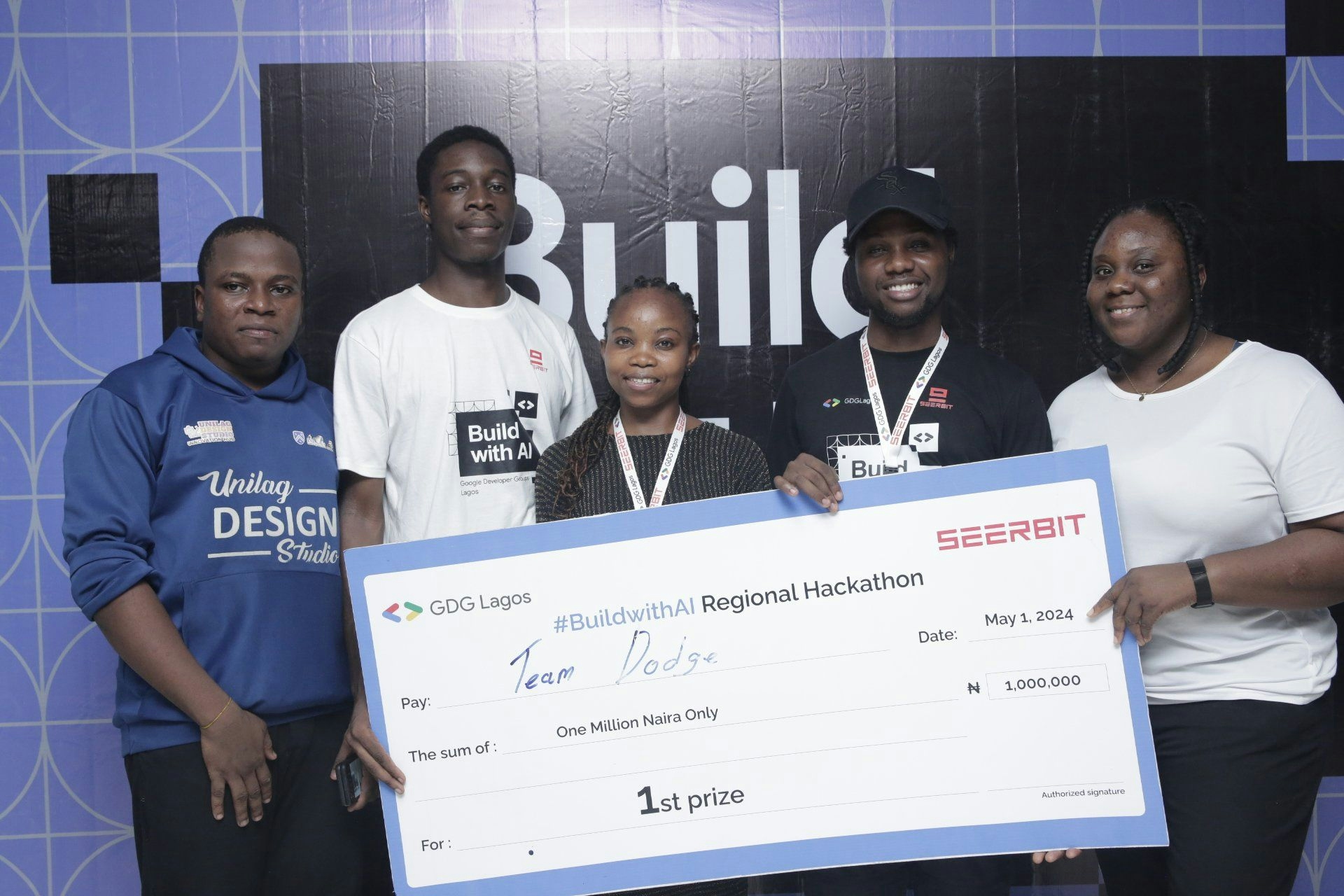 A picture of 5 people holding a competion cheque
